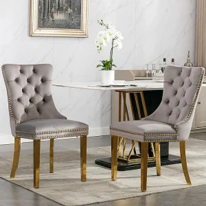 Gestoffeerde eetkamerstoel in 2 delen met poten van verchroomd roestvrij staal, spijkerkopafwerking, fluwelen bekleding, grijs en goudkleurig Gestoffeerde eetkamerstoel in 2 delen met poten van verchroomd roestvrij staal, spijkerkopafwerking, fluwelen bekleding, grijs en goudkleurig